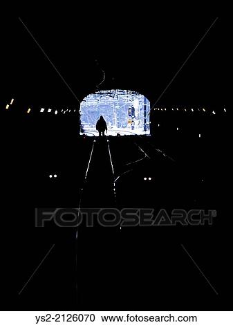 Silhouette of man entering a dark railway tunnel. Ominous and dangerous setting. View Large Photo Image Stock Image - Silhouette of man entering a dark railway tunnel. Ominous and dangerous setting.. Fotosearch