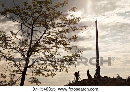 Silhouette of pilgrims leaving stones at the base of Cruz de Ferro near the village of Foncebadon along the Camino de Santiago View Large Photo Image Stock Photography - Silhouette of pilgrims leaving stones at the base of Cruz de Ferro near the village of Foncebadon along the Camino de Santiago. Fotosearch
