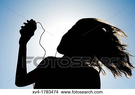 Silhouette of Pretty girl listening music on mobile at Ebro riverside of ExpoZaragoza outdoors area, Saragossa, Aragon, Spain View Large Photo Image Picture - Silhouette of Pretty girl listening music on mobile at Ebro riverside of ExpoZaragoza outdoors area, Saragossa, Aragon, Spain. Fotosearch