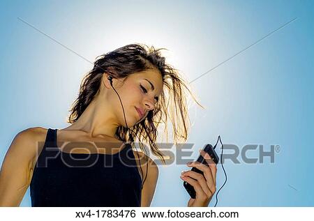 Silhouette of Pretty girl listening music on mobile at Ebro riverside of ExpoZaragoza outdoors area, Saragossa, Aragon, Spain View Large Photo Image Stock Photograph - Silhouette of Pretty girl listening music on mobile at Ebro riverside of ExpoZaragoza outdoors area, Saragossa, Aragon, Spain. Fotosearch