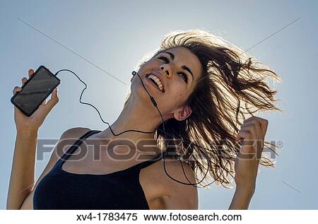 Silhouette of Pretty girl listening music on mobile at Ebro riverside of ExpoZaragoza outdoors area, Saragossa, Aragon, Spain View Large Photo Image Stock Photography - Silhouette of Pretty girl listening music on mobile at Ebro riverside of ExpoZaragoza outdoors area, Saragossa, Aragon, Spain. Fotosearch