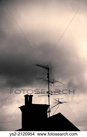 Silhouette of rooftop, chimney and antenna of old house with dark, mysterious and moody setting. View Large Photo Image Picture - Silhouette of rooftop, chimney and antenna of old house with dark, mysterious and moody setting.. Fotosearch