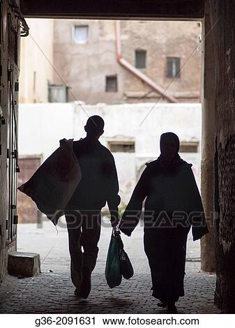 Silhouette of sanitation worker walking with garbage sack on donkey's back in the Medina in Fez, Morrocco. View Large Photo Image Stock Image - Silhouette of sanitation worker walking with garbage sack on donkey's back in the Medina in Fez, Morrocco.. Fotosearch