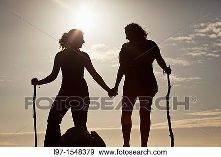 Silhouette of two girls holding hands at sunset, finisterre View Large Photo Image Stock Photo - Silhouette of two girls holding hands at sunset, finisterre. Fotosearch