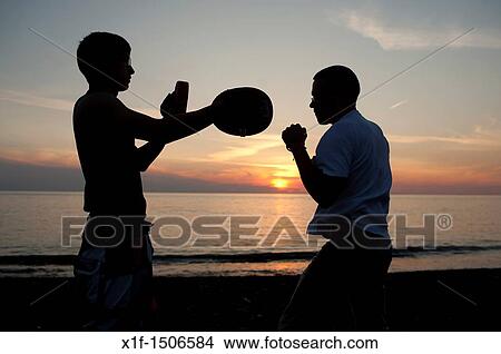 silhouette of Two men sparring boxing at sunset UK View Large Photo Image Picture - silhouette of Two men sparring boxing at sunset UK. Fotosearch