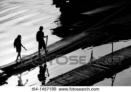 Silhouette of two people, who go over a bridge View Large Photo Image Stock Photo - Silhouette of two people, who go over a bridge. Fotosearch