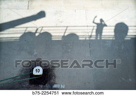 Silhouette Shadow of a boat deck with a passenger, moored at the dock, Alcudia, Mallorca, Spain. View Large Photo Image Stock Image - Silhouette Shadow of a boat deck with a passenger, moored at the dock, Alcudia, Mallorca, Spain.. Fotosearch