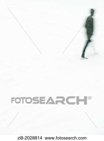 Picture - Silhouette with blurred motion of man walking in snowfall.. Fotosearch
