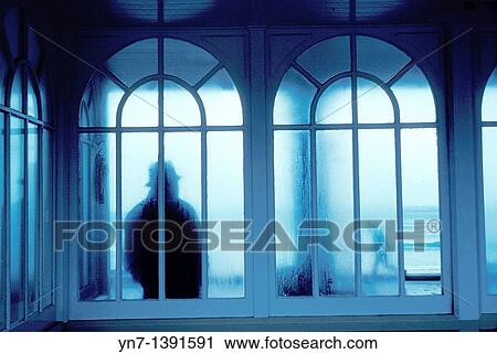 Silhouetted figure seen through wet misty glass arches in a scene invoking mystery and wonder View Large Photo Image Stock Image - Silhouetted figure seen through wet misty glass arches in a scene invoking mystery and wonder. Fotosearch