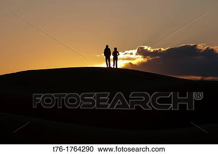 silhouetted on a sand dune at sunrise in the Sahara near Merzouga, Erg Chebbi, Morocco View Large Photo Image Stock Image - silhouetted on a sand dune at sunrise in the Sahara near Merzouga, Erg Chebbi, Morocco. Fotosearch