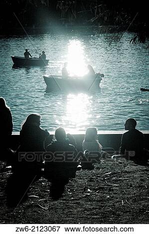 Silhouettes of a family by the lake View Large Photo Image Stock Photo - Silhouettes of a family by the lake. Fotosearch
