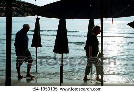 Silhouettes of older people, walking at the beach View Large Photo Image Stock Photography - Silhouettes of older people, walking at the beach. Fotosearch