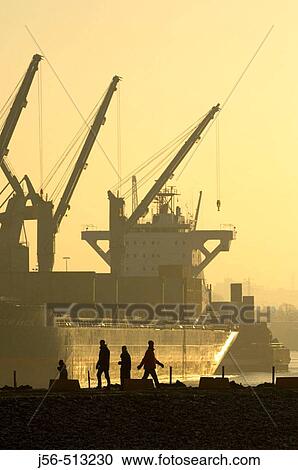 Stock Image - Silhouettes on waterfront, Hamburg, Germany. Fotosearch