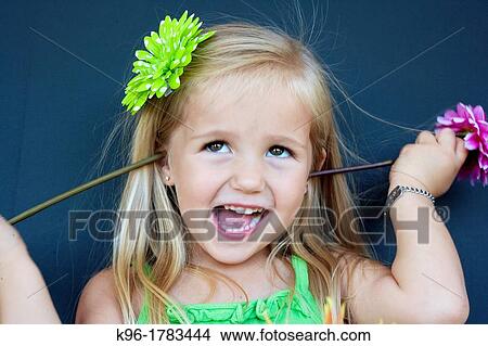 silly little girl putting flowers in her ears View Large Photo Image Picture - silly little girl putting flowers in her ears. Fotosearch