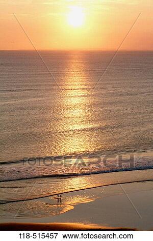 Silouhette of couple on beach at sunset View Large Photo Image Stock Photo - Silouhette of couple on beach at sunset. Fotosearch