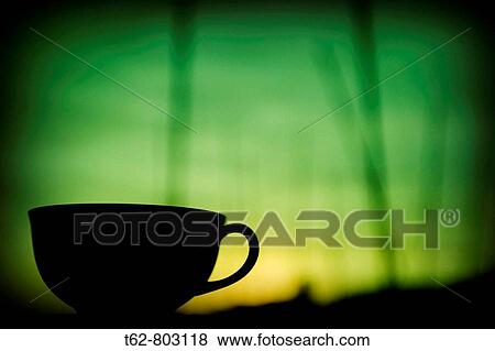 Stock Photo - Silueta de una taza de t? contra el cielo del atardecer.. Fotosearch