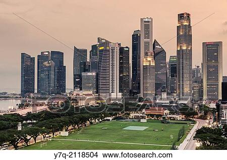 Singapore Downtown Core skyline overlooking The Padang sporting field. View Large Photo Image Picture - Singapore Downtown Core skyline overlooking The Padang sporting field.. Fotosearch