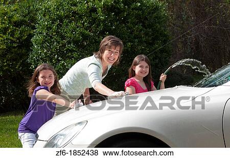 Single mom and daughters family washing car at home in driveway together with hose and having fun View Large Photo Image Stock Photo - Single mom and daughters family washing car at home in driveway together with hose and having fun. Fotosearch