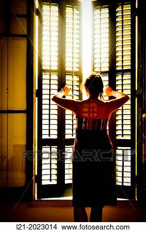 Single woman opening a window. View Large Photo Image Picture - Single woman opening a window.. Fotosearch