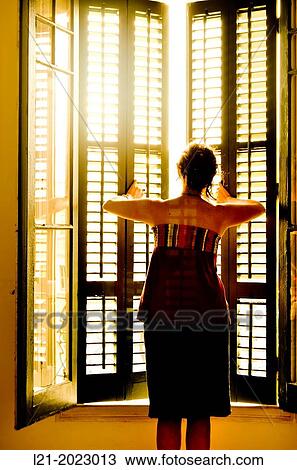 Single woman opening a window. View Large Photo Image Stock Image - Single woman opening a window.. Fotosearch