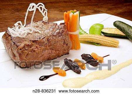 Stock Image - Sirloin steak served with vegetables. Fotosearch