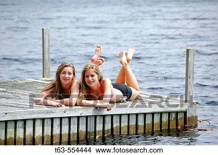 sisters 13 and 18 yrs laying on dock together View Large Photo Image Picture - sisters 13 and 18 yrs laying on dock together. Fotosearch