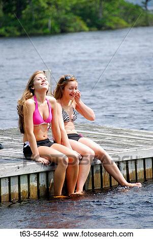 sisters 13 and 18 yrs sitting on dock together View Large Photo Image Stock Image - sisters 13 and 18 yrs sitting on dock together. Fotosearch