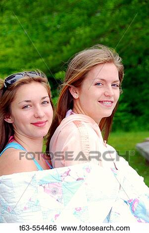 sisters 13 and 18 yrs together with blanket wrapped around View Large Photo Image Stock Photograph - sisters 13 and 18 yrs together with blanket wrapped around. Fotosearch