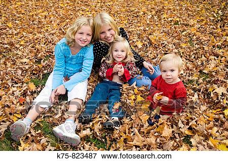 sisters and cousins enjoying the autumn leaves View Large Photo Image Stock Photo - sisters and cousins enjoying the autumn leaves. Fotosearch