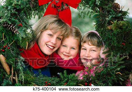 Sisters framed by Christmas wreaths View Large Photo Image Picture - Sisters framed by Christmas wreaths. Fotosearch