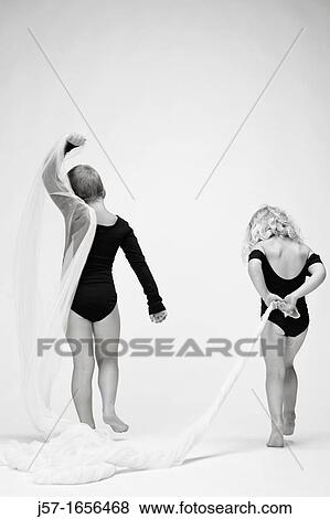 Sisters in black leotards playing with fabric in the studio on a white background View Large Photo Image Stock Photo - Sisters in black leotards playing with fabric in the studio on a white background. Fotosearch
