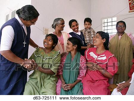 Stock Image - Sisters Leela and Achama greeting patients, SSSMILE village, Kerala, India. Fotosearch