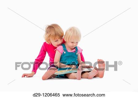 sisters looking at chidren's book - isolated on white View Large Photo Image Stock Photography - sisters looking at chidren's book - isolated on white. Fotosearch