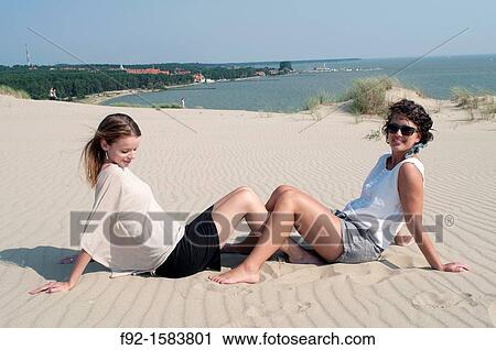 Stock Image - Sisters on sand dunes, Nida, Lithuania. Fotosearch