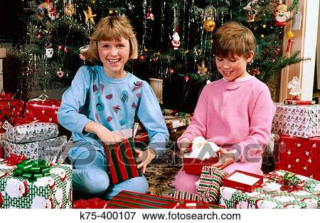 Sisters opening Christmas presents View Large Photo Image Stock Photo - Sisters opening Christmas presents. Fotosearch