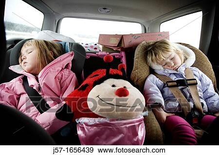 Sisters sleeping in the car driving home after a hard day playing View Large Photo Image Stock Photo - Sisters sleeping in the car driving home after a hard day playing. Fotosearch