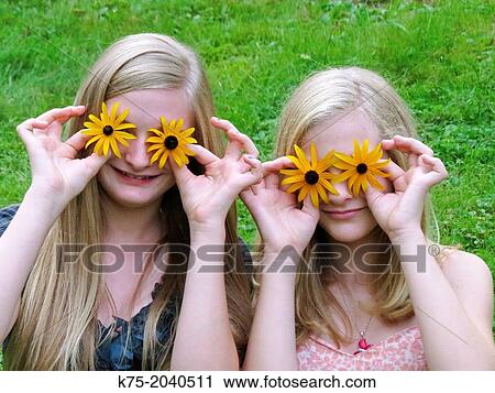 Sisters with flowers on their eyes View Large Photo Image Stock Image - Sisters with flowers on their eyes. Fotosearch