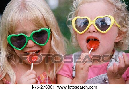 sisters with heart sunglasses and lollipops View Large Photo Image Stock Image - sisters with heart sunglasses and lollipops. Fotosearch