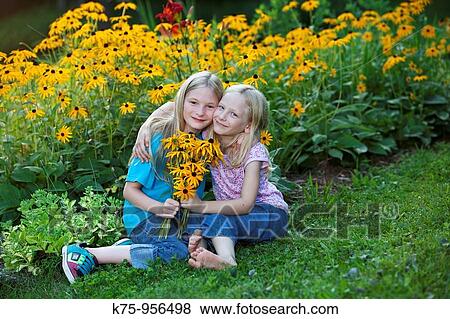 sisters with wildflowers View Large Photo Image Stock Photo - sisters with wildflowers. Fotosearch