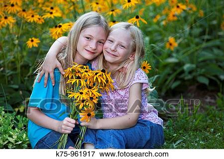 Stock Photo - sisters with wildflowers. Fotosearch