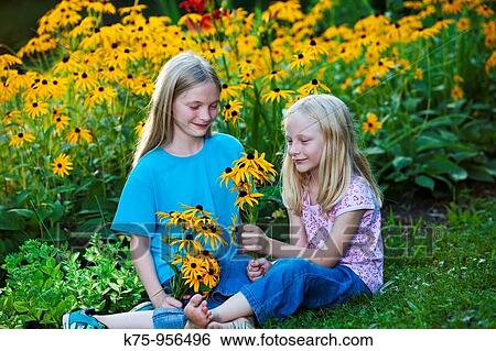 Stock Photograph - sisters with wildflowers. Fotosearch