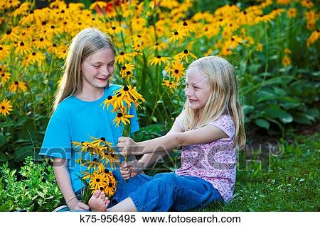 Stock Photography - sisters with wildflowers. Fotosearch