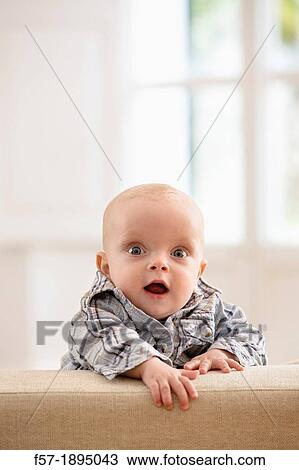 Six month year old baby holding on to the back of a sofa View Large Photo Image Stock Image - Six month year old baby holding on to the back of a sofa. Fotosearch