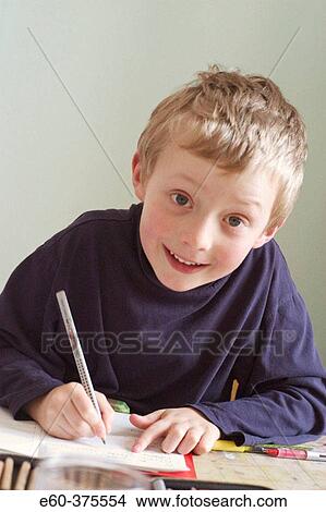 Six year old boy sitting at desk doing homework View Large Photo Image Picture - Six year old boy sitting at desk doing homework. Fotosearch