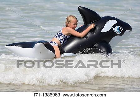Six year old girl at the beach playing in the surf on inflatable Orca Mimiwhangata Northland, New Zealand View Large Photo Image Stock Image - Six year old girl at the beach playing in the surf on inflatable Orca Mimiwhangata Northland, New Zealand. Fotosearch