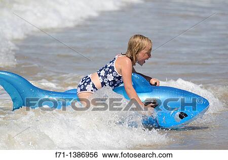 Six year old girl at the beach playing in the surf on inflatable shark Mimiwhangata Northland, New Zealand View Large Photo Image Stock Photograph - Six year old girl at the beach playing in the surf on inflatable shark Mimiwhangata Northland, New Zealand. Fotosearch