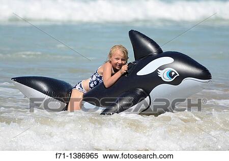 Six year old girl at the beach playing in the surf on inflatable Orca Mimiwhangata Northland, New Zealand View Large Photo Image Stock Photography - Six year old girl at the beach playing in the surf on inflatable Orca Mimiwhangata Northland, New Zealand. Fotosearch