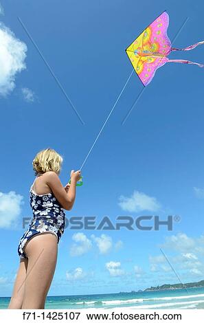 Stock Photo - Six year old girl flying a kite at the beach Mimiwhangata, Northland, New Zealand. Fotosearch