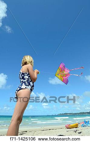 Stock Photograph - Six year old girl flying a kite at the beach Mimiwhangata, Northland, New Zealand. Fotosearch