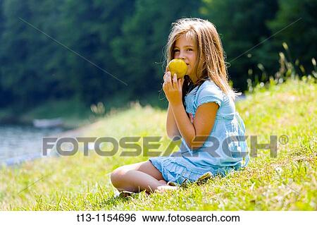 Stock Photograph - Six year old girl is eating a pear. Fotosearch